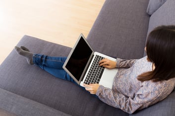 Woman using laptop computer on sofa